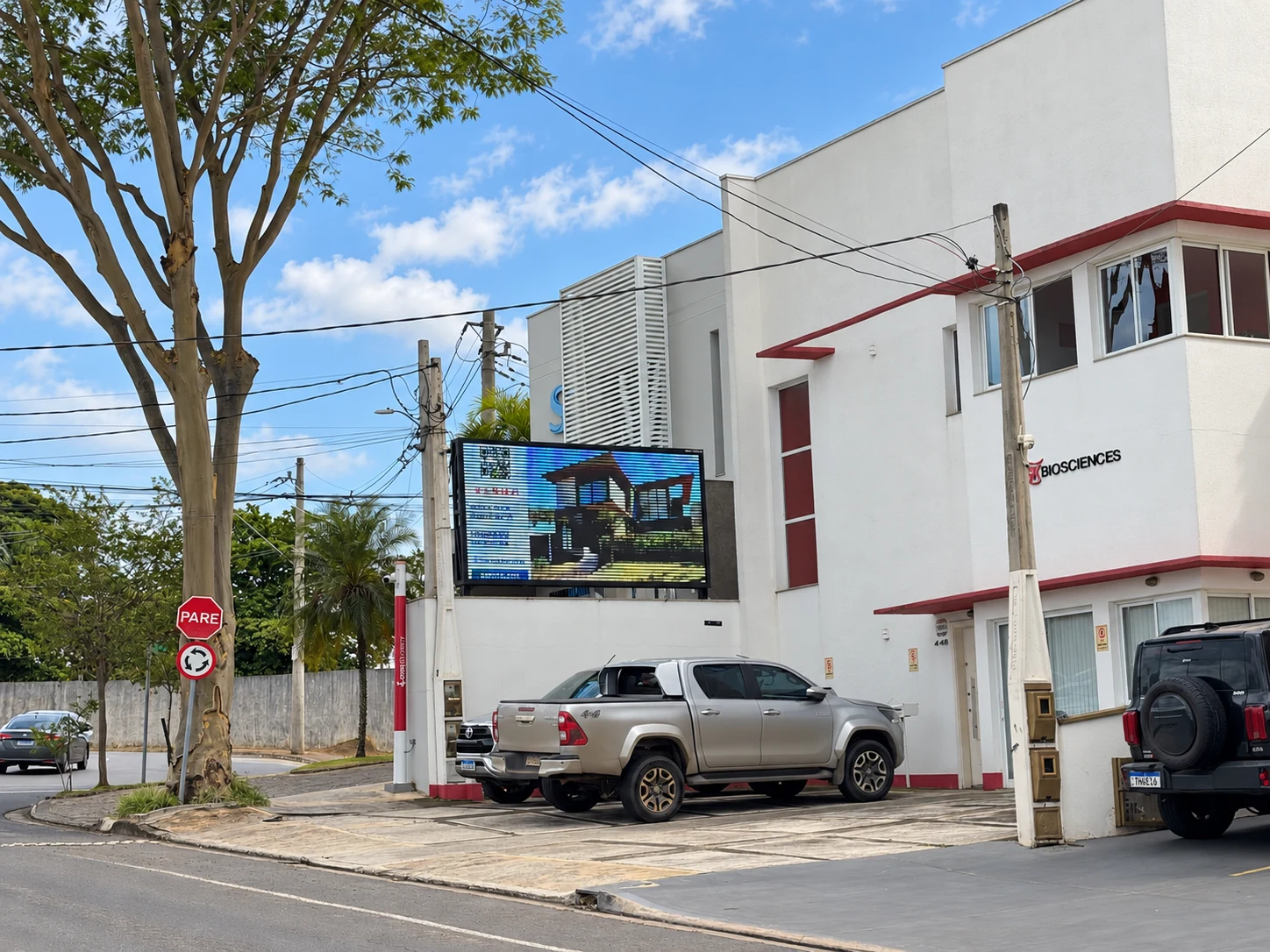 Painel com anúncio e vista da aproximação pela rua